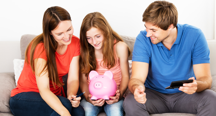 parents with daughter holding piggy bank