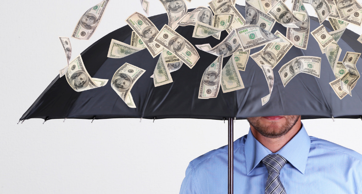 under umbrella with money falling out of sky