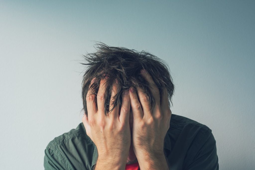 man with face in palms