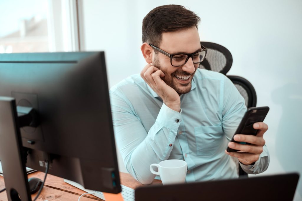 man smiling at cell phone