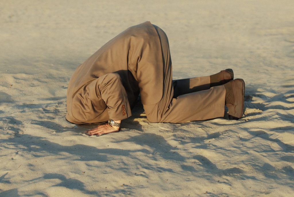 man with head stuck in sand